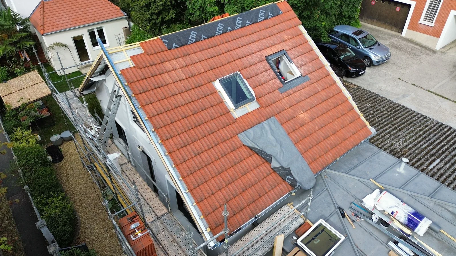 Pose de tuiles en cours avec fenêtres de toit Velux — Toiture tuile