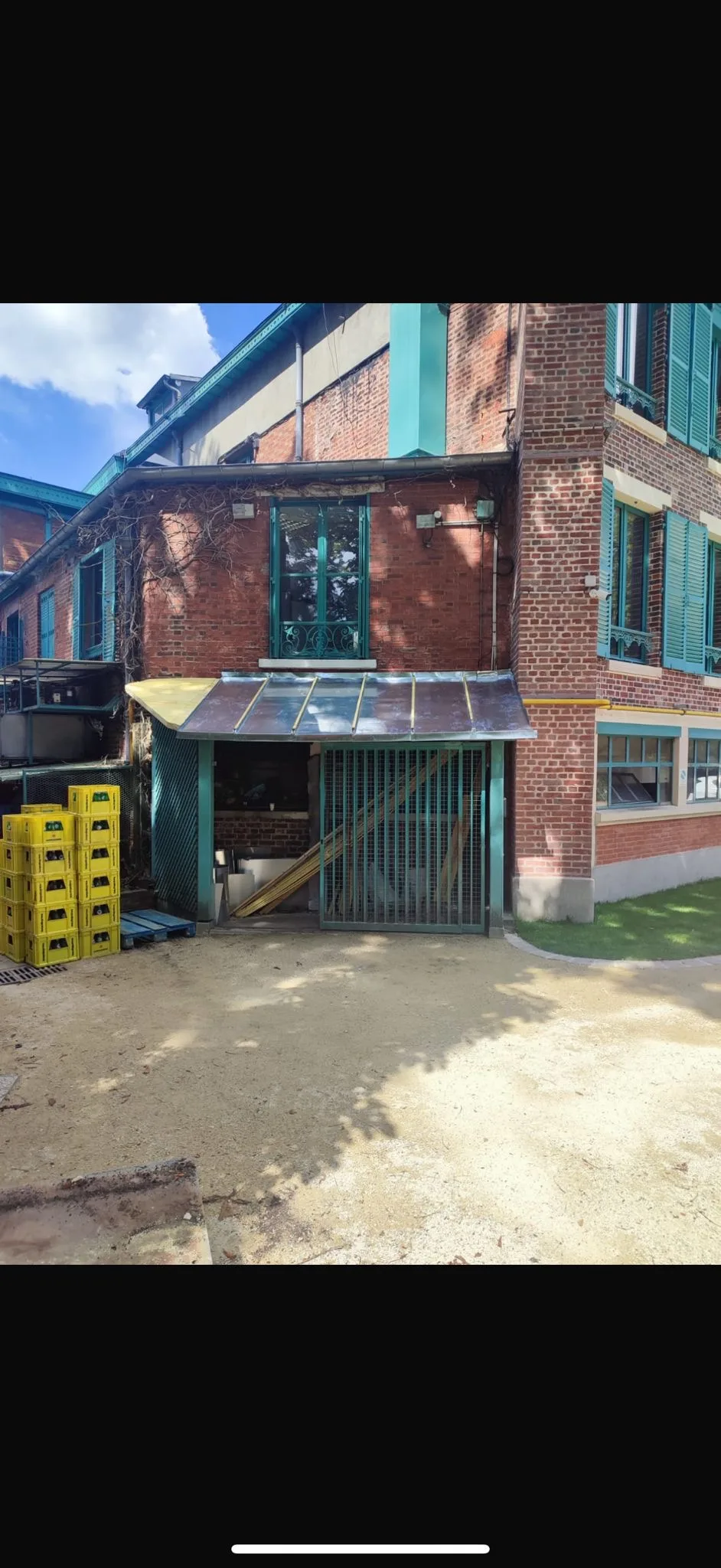 Marquise verrière et portail métallique teal sur bâtiment en briques — Zinguerie