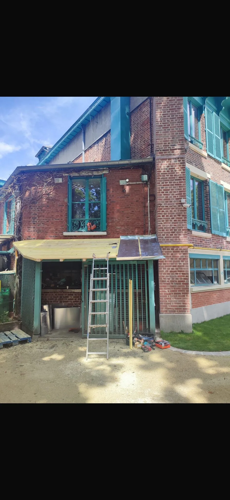 Construction d'un auvent en bois avec couverture polycarbonate sur bâtiment en brique — Charpente